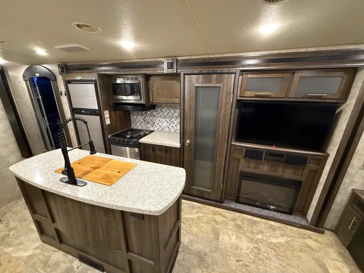 Experience comfort in this RV rental! Kitchen island, full appliances, cozy fireplace, and TV offer home-like convenience.. Highland Ridge RV Light 2018