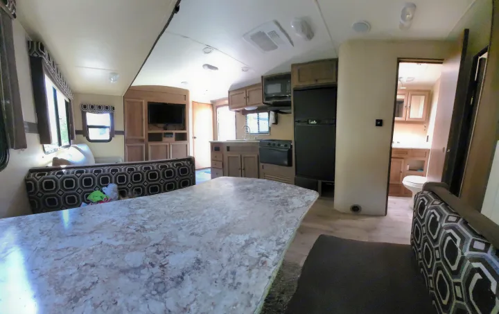 Step inside this bright RV rental, showcasing a functional kitchen, comfortable dinette, and private bath.. Cruiser RV Radiance 2015