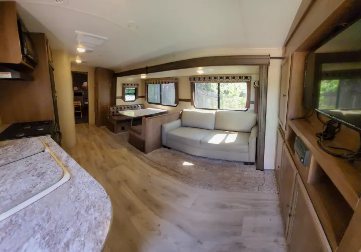 Spacious RV rental interior with cozy living area, sofa, dinette, and kitchen. Perfect for your next adventure!. Cruiser RV Radiance 2015