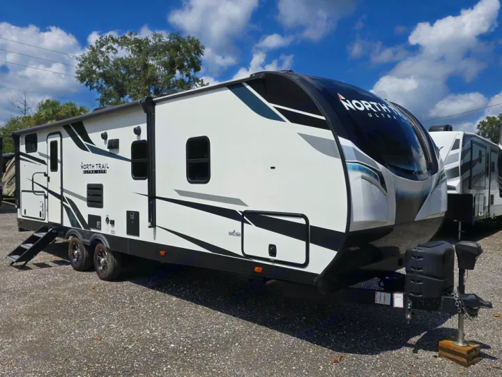 Front view of a sleek, white & black North Trail Ultra Lite travel trailer for rv rental. Ready for adventure.. Heartland North Trail 29BHP 2022