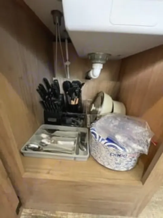 RV rental kitchen: Under-sink storage of utensils, paper plates, and a blender for compact living efficiency.. Forest River Campsite Reserve 26CJ 2025