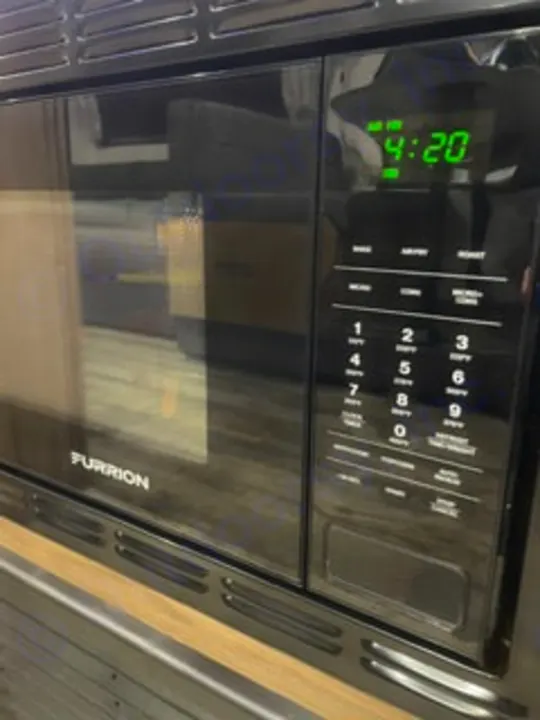 RV rental comfort: A black Furrion microwave (4:20) with digital display & touch controls, perfect for travel kitchen use.. Forest River Campsite Reserve 26CJ 2025