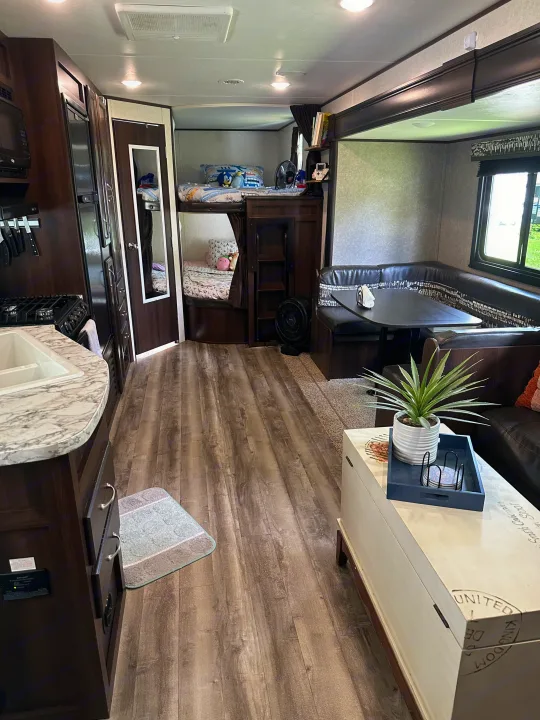 Spacious RV rental interior featuring a kitchen, dining booth, and bunk beds for comfortable travel.. Jayco Jay Flight 2018