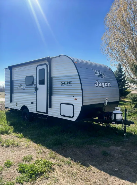 This Jayco Jay Flight travel trailer, ideal for RV rental, sits ready for adventure under a clear blue sky.. Jayco Jay Flight SLX 170BHW 2025