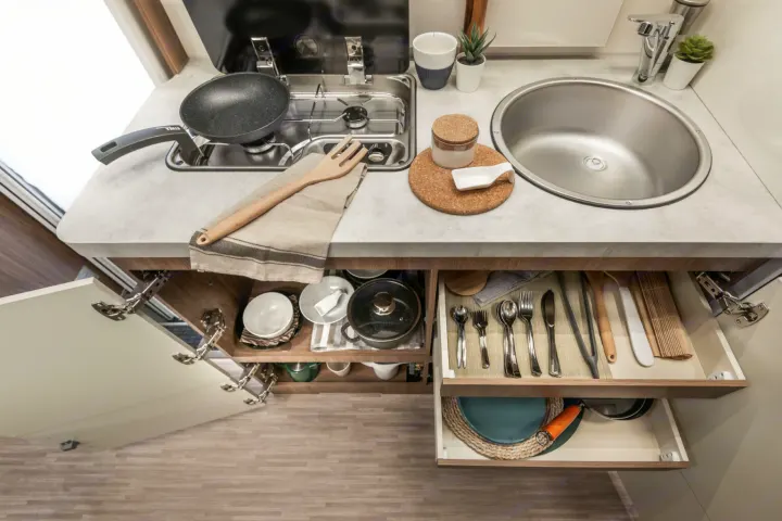 An RV rental kitchen, neatly organized with a stove, sink, and hidden storage for cooking and dining essentials.. Elnagh baron 20 2025