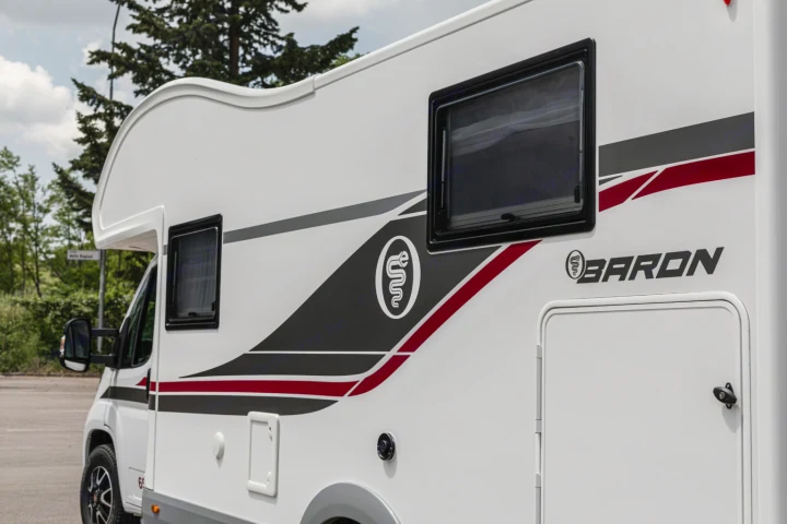 White **rv rental** with modern gray, red, and black graphics, featuring a unique logo and "BARON" branding on its side.. Elnagh baron 20 2025
