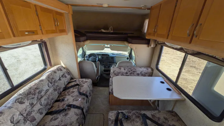 Spacious rv rental interior showing the dinette, sofa, and over-cab bunk bed, ideal for comfortable travel.. Forest River Sunseeker 2010