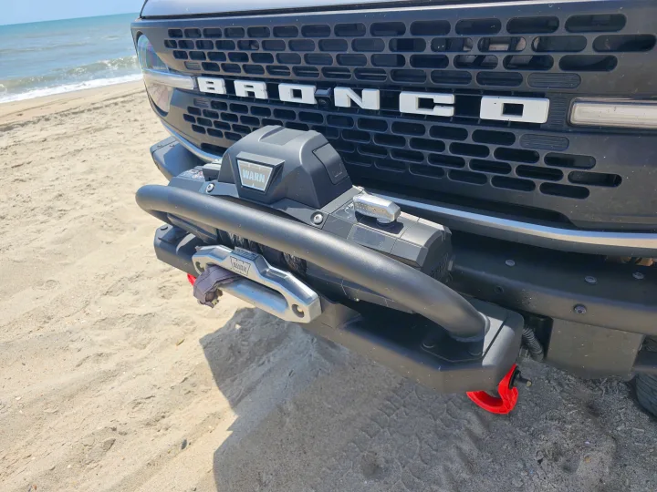 Bronco with WARN winch on a sandy beach. Ideal for off-road adventures, similar to an RV rental trip.. Ford Bronco Outer Banks 2022