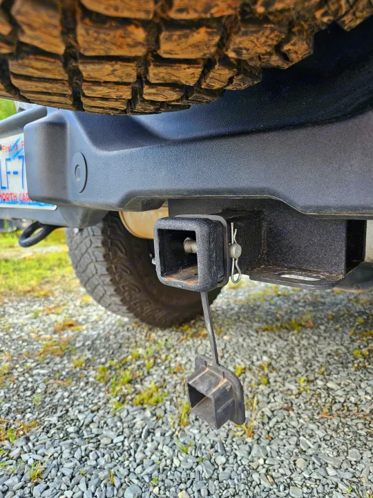 Robust trailer hitch on an RV rental, essential for towing. A spare tire and North Carolina license plate are visible.. Ford Bronco Outer Banks 2022