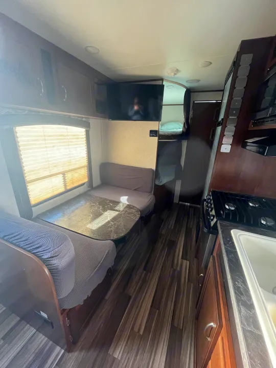 Cozy RV rental interior: dinette, kitchen, and bunk beds offer a complete living space.. Jayco Jaycoflight 2017