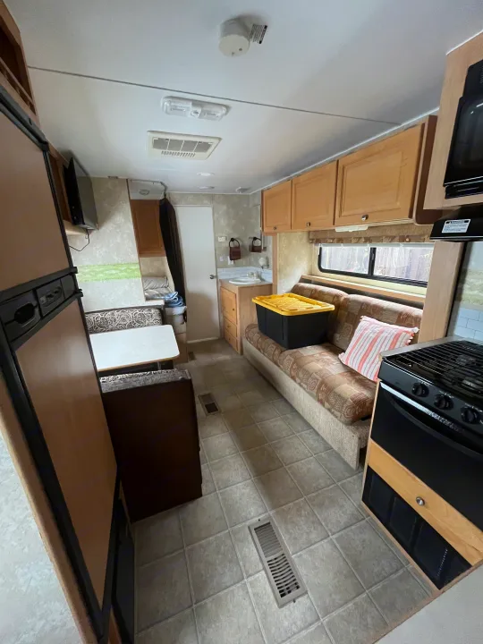 Bright RV rental interior featuring a full kitchen, dinette, fridge, and comfortable sofa. Your next adventure awaits!. Thor Motor Coach Wave 2007