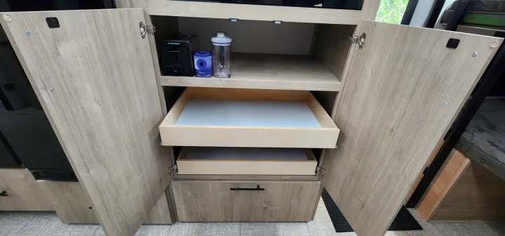 RV rental: Open light wood cabinet with shelves holding a toaster and blender, plus two pull-out drawers.. Grand Design Imagine 2800BH 2025