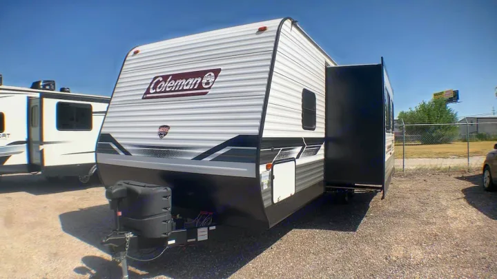 Coleman travel trailer with slide-out extended, ready for your next RV rental adventure. Parked on gravel.. Coleman Lantern 2022