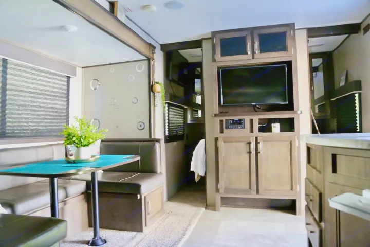 Spacious RV rental interior. Features dining booth, TV entertainment center, and modern design for comfortable travel.. Jayco Jay Flight SLX 2020