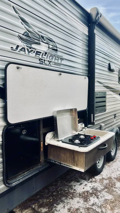 This RV rental features a convenient slide-out outdoor kitchen with a two-burner stove and sink, perfect for camping.. Jayco Jay Flight SLX 2020