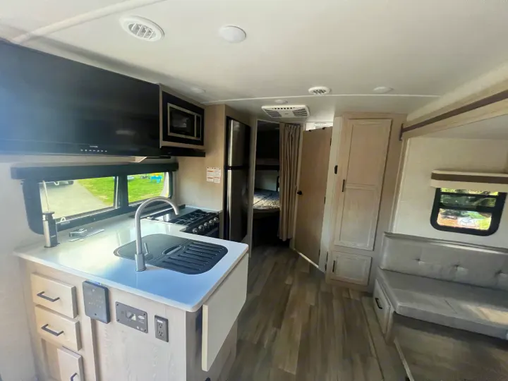 Spacious RV rental interior: modern kitchen, cozy dinette, and bunk beds visible. Ready for your road trip!. Forest River Rockwood Mini Lite 2023