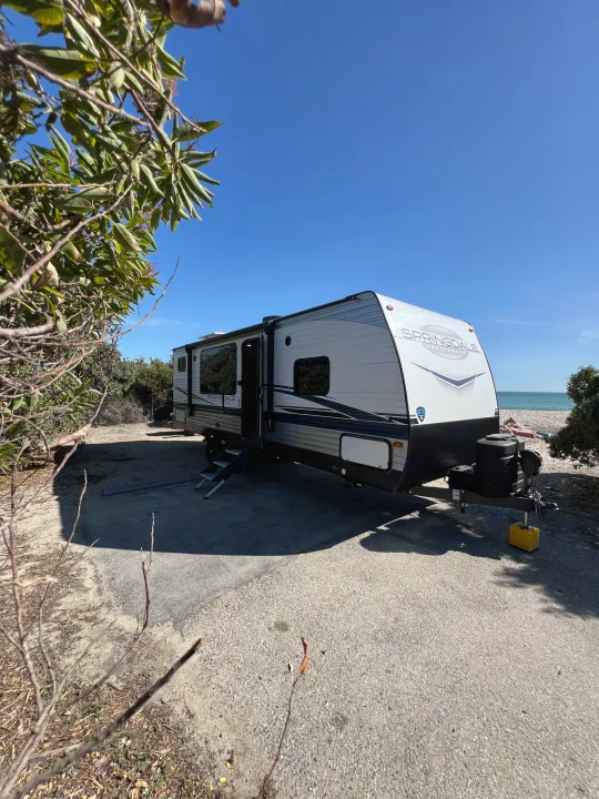 Springdale RV rental parked at a sunny beach campsite with ocean views. Perfect for your next outdoor adventure.. Keystone RV Springdale 2023