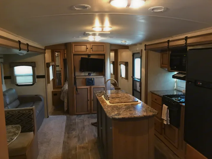 Explore a bright RV rental: full kitchen, comfy living space, and bedroom setup inside a modern travel trailer.. Cruiser RV Shadow Cruiser 2015