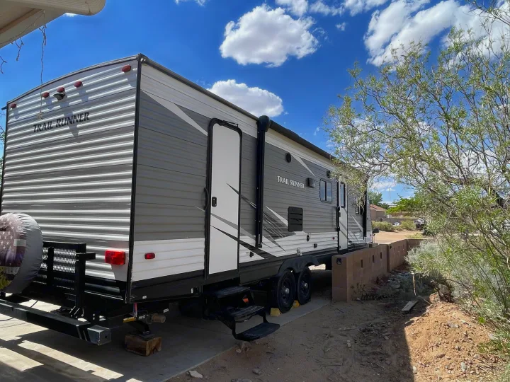 RV rental: A grey and white 'Trail Runner' travel trailer parked outdoors on a concrete pad under blue sky.. Heartland RVs Trail Runner 2019