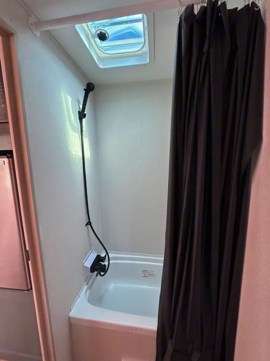 Compact RV rental bathroom featuring a shower, tub, and ceiling vent for your travels.. Heartland Eddie Bauer 2025