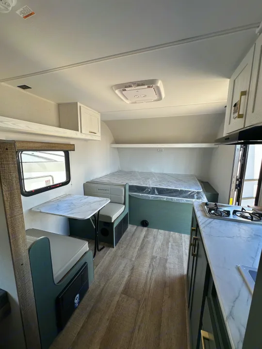 Explore this RV rental! Interior shows a bright dinette, bed, and modern kitchen. Great for camper adventures.. Heartland Eddie Bauer 2025
