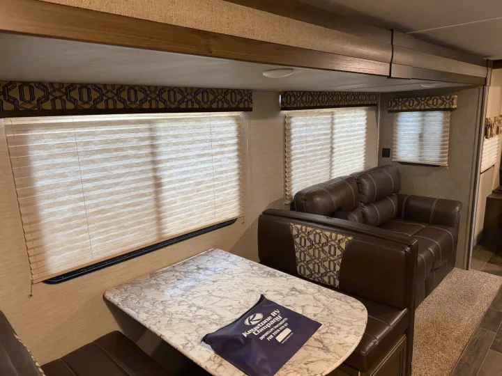 This comfortable RV rental features a cozy dinette and sofa in its inviting living area, ready for your travel trailer adventures.. Keystone RV Bullet Ultra Lite 2019