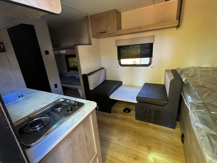 An RV rental interior with compact kitchen, dinette, and bunk beds, offering a versatile living and sleeping area.. Heartland Mallard Mallard 2025
