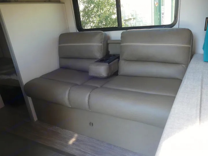 RV rental interior: Modern gray upholstered seating with armrest and cup holders, ideal for travel comfort.. Forest River Aurora 2024