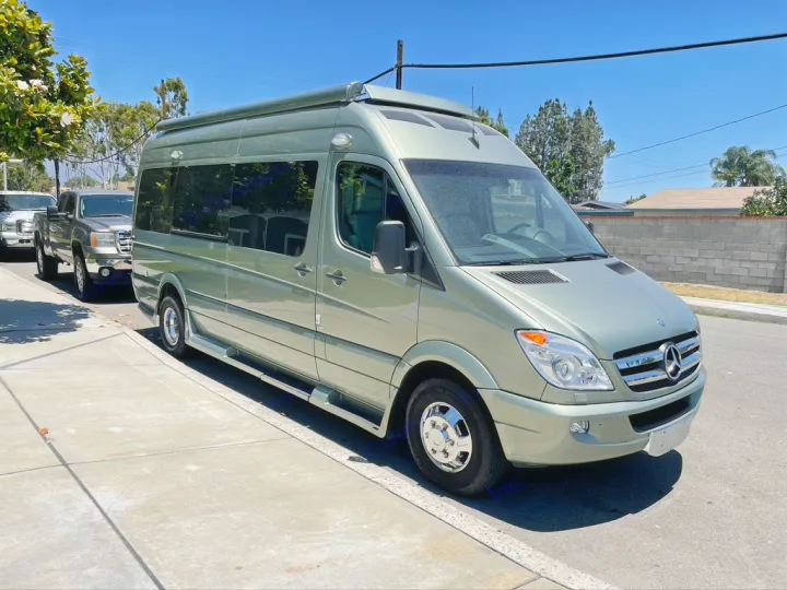 Light green Mercedes-Benz Sprinter RV rental van, with a high roof, parked on a sunny street. Ready for your next adventure.. Roadtrek Roadtrek Class B 2013