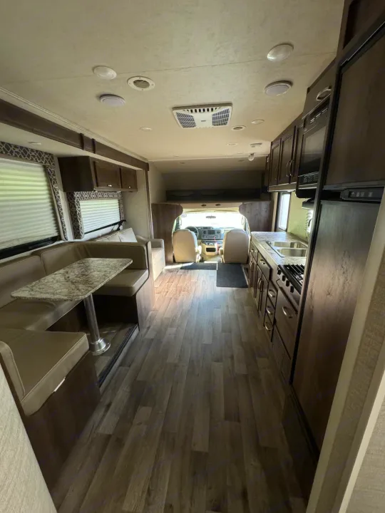 Spacious RV rental interior featuring a dinette, kitchen, and forward cab area, ideal for travel.. Jayco Redhawk 2019