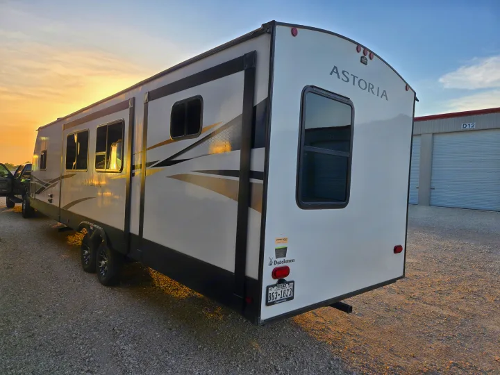 Golden hour glow illuminates an Astoria travel trailer, perfect for your next RV rental adventure.. Dutchman Astroia 2022