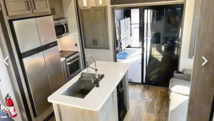 Discover this RV rental's modern kitchen with island, stainless appliances, and versatile rear garage. Great for trips!. Keystone RV Raptor Toy Hauler 2020