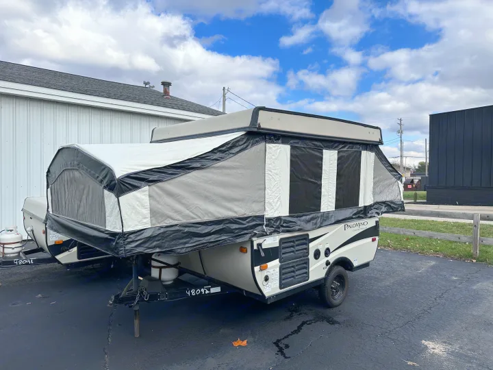 A modern Palomino pop-up camping trailer, ready for your next RV rental adventure, parked on asphalt under cloudy skies.. Palomino Other 2017