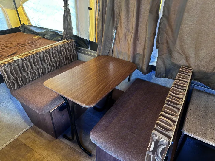 This RV rental shows a camper interior with a dinette table, patterned cushions, and a pop-out bed.. Palomino Other 2017