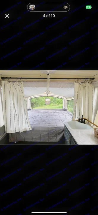 Cozy pop-up RV rental interior: bed, sink, and scenic views. Your adventure awaits!. Coleman Grand Tour 2002