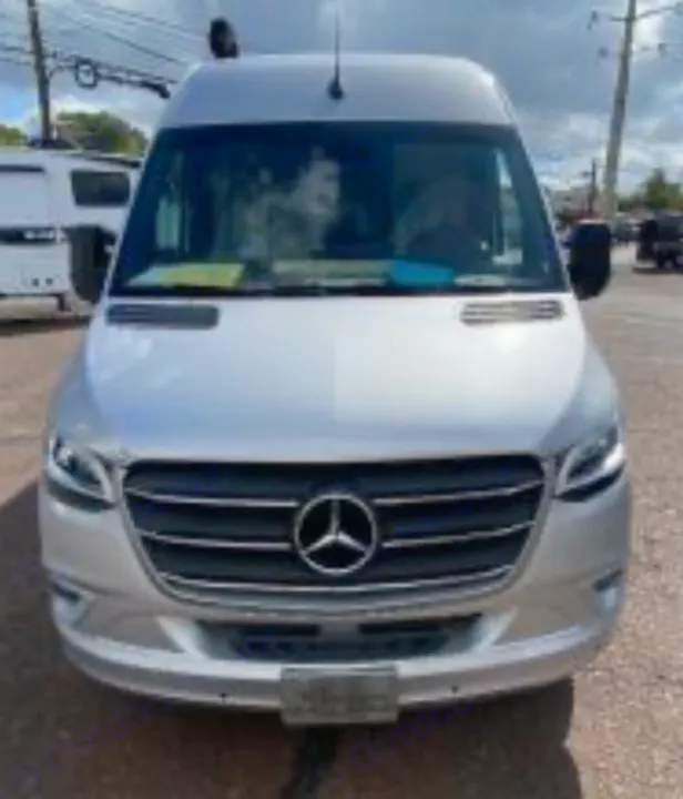 Front view of a silver Mercedes-Benz Sprinter van, an ideal RV rental. This modern camper is parked outside.. Coachmen Galleria Li 3 (24Q) 2021