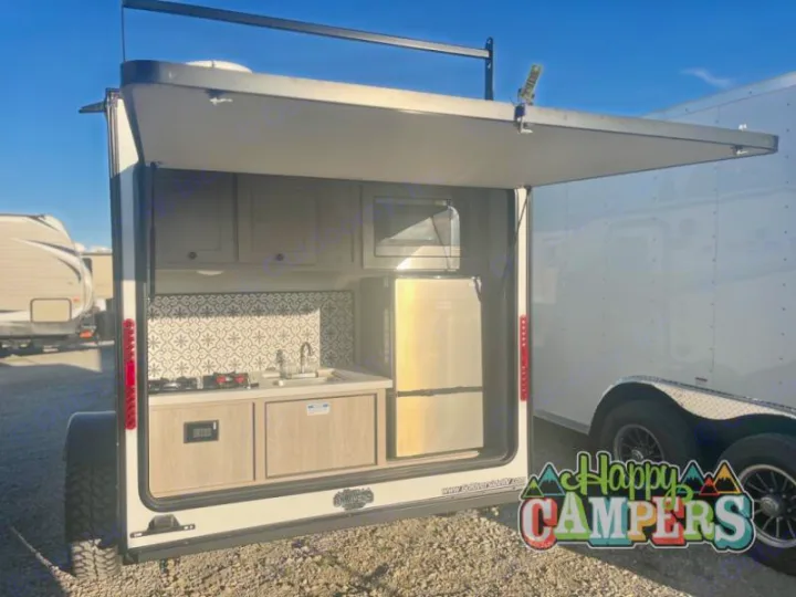 See this RV rental's impressive outdoor kitchen! Features include a stove, sink, fridge, microwave, and storage, perfect for camping.. Riverside RV Intrepid 2023