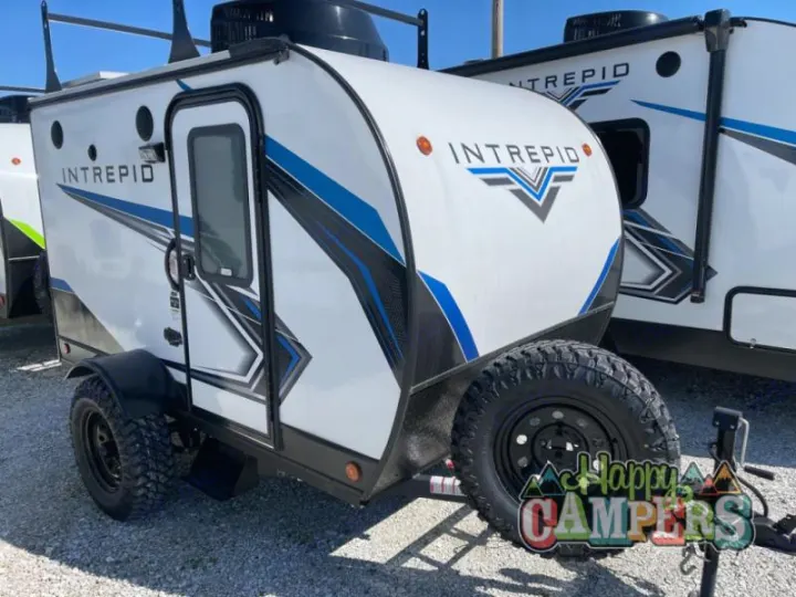 Front view of a rugged Intrepid travel trailer RV rental, white with blue accents, ideal for off-grid adventures.. Riverside RV Intrepid 2023