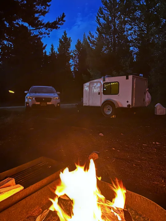 Campfire glows by RV rental teardrop trailer & car at night. Perfect for your outdoor adventure!. Hiker Deluxe 2018