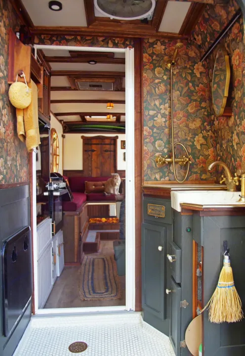 Experience this custom rv rental: a cozy interior with a floral bath, brass fixtures, and a welcoming living area with a cat.. Dodge Ram Promaster 3500 2023