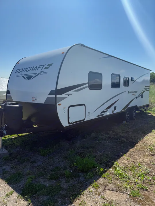 Starcraft Autumn Ridge travel trailer for potential RV rental. White with black accents on a sunny day.. Starcraft Autumn Ridge 2023