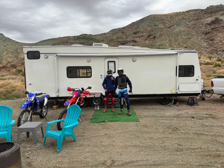RV rental provides the perfect basecamp for two dirt bikers and their motorcycles in a desert landscape.. Thor Motor Coach Tahoe 2003