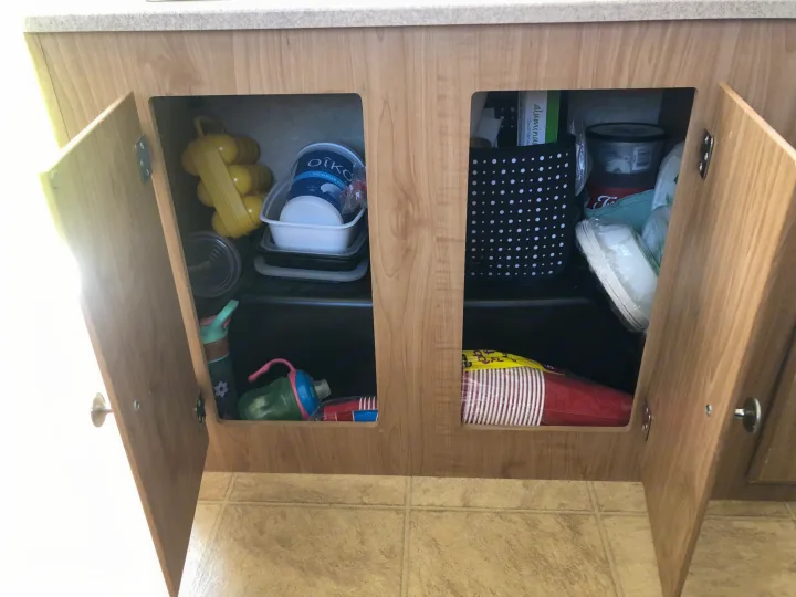 RV rental kitchen cabinets neatly store reusable containers, disposable cups, and travel supplies, perfect for camping.. Fleetwood santa fe 2008