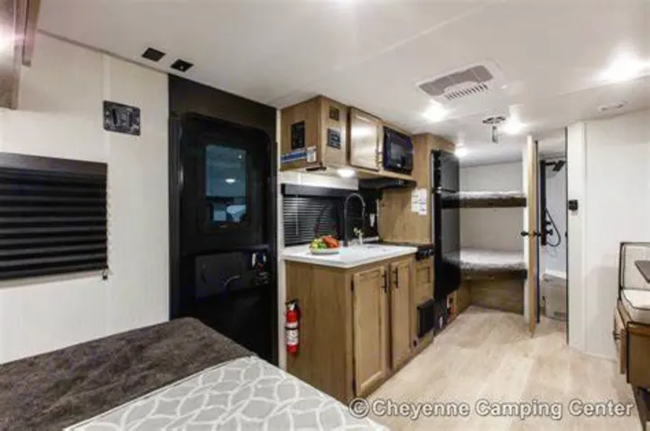 This RV rental's compact interior features a kitchen, bed, bunk beds, and a bathroom, perfect for your next trip.. Cherokee WOLF PUP BLACK LABEL 17JWBL 2025
