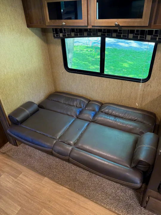 RV rental: Dark leather sleeper sofa and large windows with a view of green landscape.. Dutchmen Coleman Lantern 2019