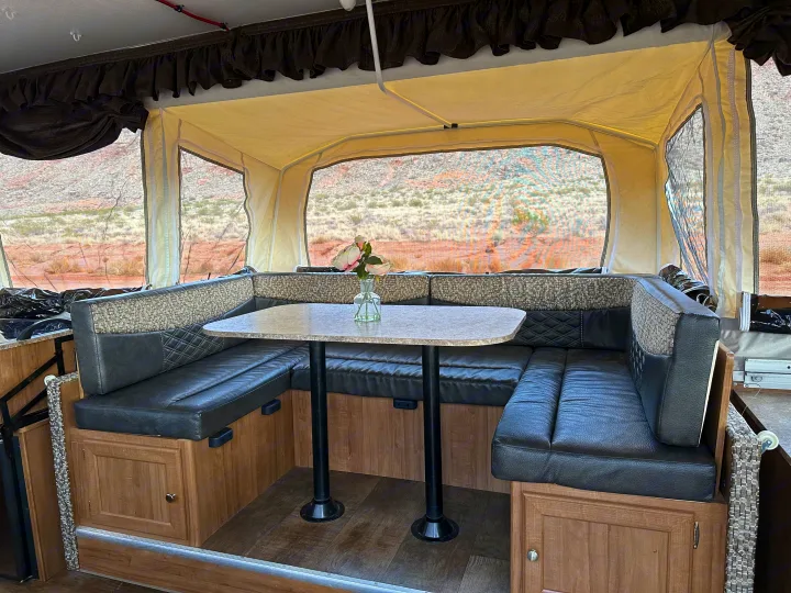 Spacious RV rental pop-up camper interior with a cozy dinette, perfect for enjoying desert views.. Forest River Rockwood Premier 2017