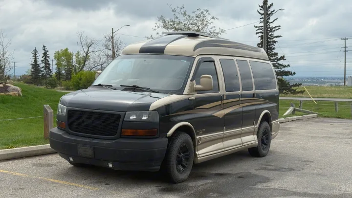 High-top black & gold custom conversion van, great for RV rental adventures. Parked on asphalt.. Gmc Custom Savana 2007