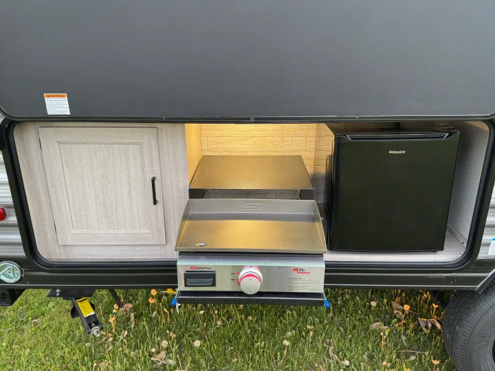 RV rental: Compact outdoor kitchen with built-in griddle, mini-fridge & storage.. Forest River 184BHS 2025