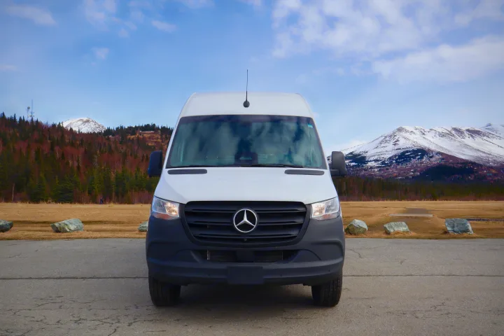 An RV rental - a white Mercedes-Benz Sprinter van - parked against snowy mountains and fields.. Mercedes-Benz Sprinter 2025