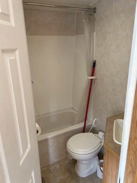 Inside a compact RV rental bathroom: a shower/tub, toilet, and small sink. All essentials for comfortable travel on the road.. Frontier FW255 2012